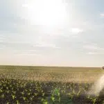 Tractor spraying herbicides and pesticides on field