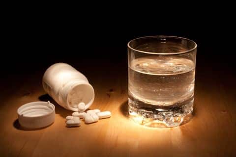 tylenol pills and glass of water