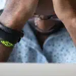 Black man getting frustrated in front of laptop
