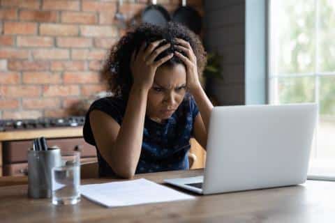 Woman confused in front of laptop