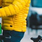 Man in yellow jacket with bike delivering food